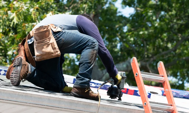 roof technician using power tools to repair roof shingles