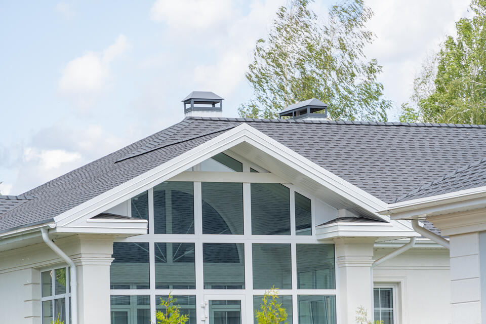 does a new roof increase home value-close up view of white home with new gray shingled roof