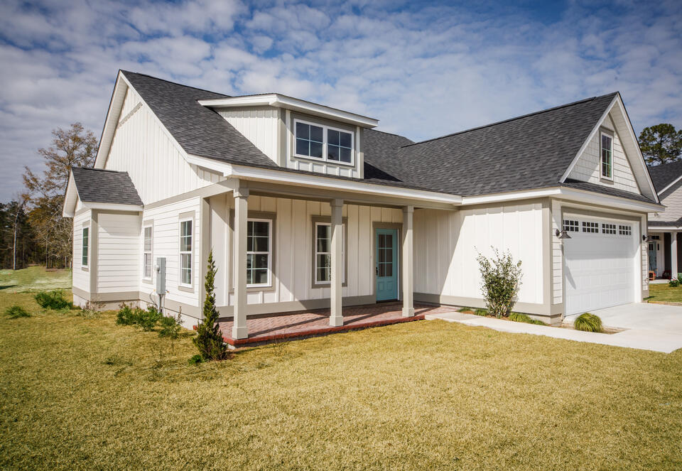 does a new roof increase home value-white sided house with new gray shingled roof