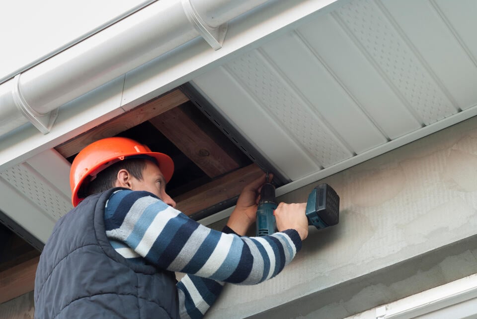 soffit repair-man wearing a hard hat repairing soffits